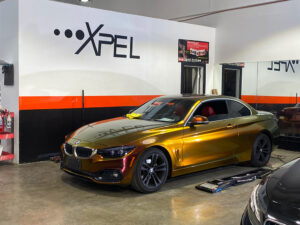 BMW metallic vinyl wrap color change - Xpel: Gloss Rising Sunred/Gold